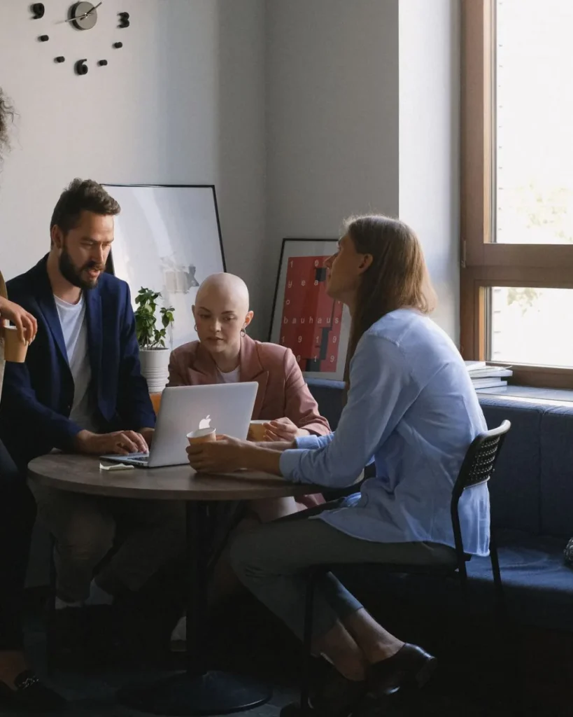 Nonprofit team members collaborating around a laptop in a welcoming workspace